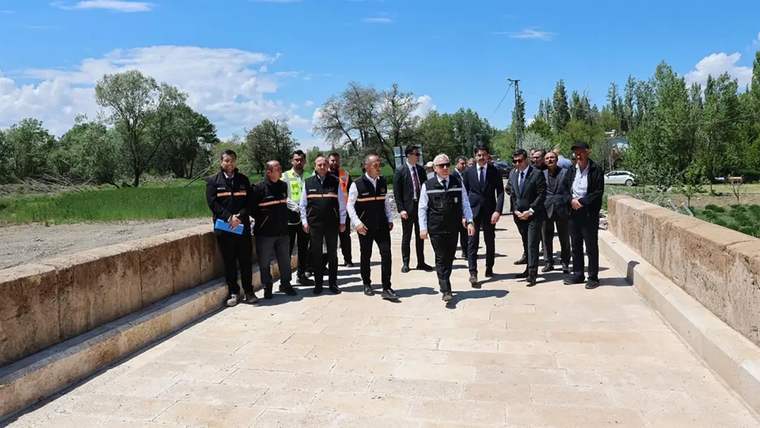 Bir grup insan, Tecer Köprüsü üzerinde yürüyerek inceleme yapıyor.