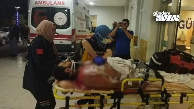 Yaralı bir kişi, sedyede hastaneye taşınıyor; sağlık ekipleri müdahale ediyor.