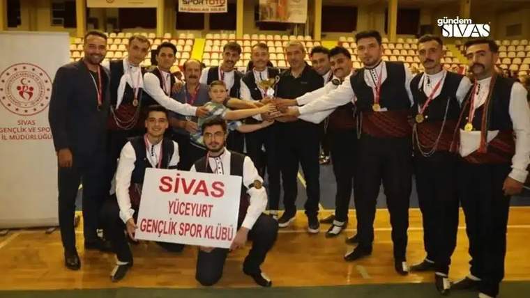 Madalyalı bir grup genç, kupayı tutarak üzerinde Sivas Yüceyurt Gençlik Spor Kulübü yazan pankartla poz veriyor.