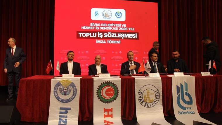Sivas Belediyesi ve Hizmet İş Sendikası arasında toplu iş sözleşmesi imza töreni, sahnede masanın önünde gerçekleşiyor.