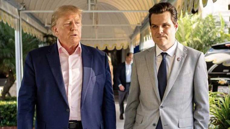 Donald Trump ve Matt Gaetz, bir koridorda yan yana yürürken görülüyor.