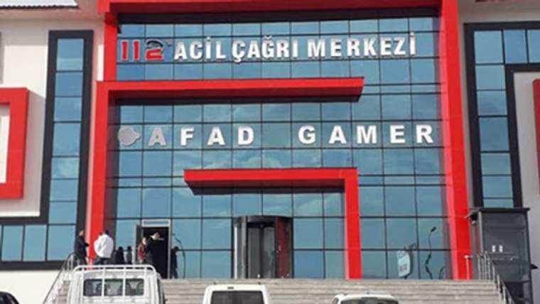 Cam cephesinde “112 Acil Çağrı Merkezi” ve “AFAD GAMER” yazıları bulunan binanın girişinde insanlar görülüyor.