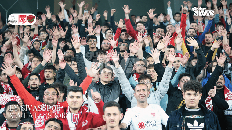 Tribünde çok sayıda taraftar ellerini havaya kaldırırken bazıları Sivaspor atkıları taşıyor.