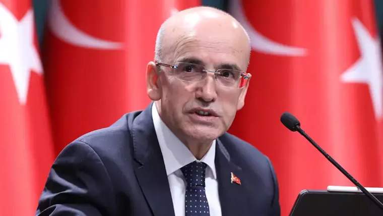 Kırmızı arka planda Türk bayrakları ile bir kişi konuşma yapıyor.