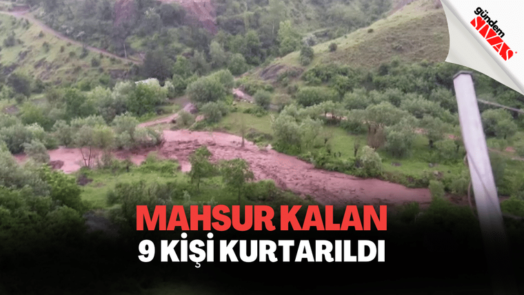 Yeşil ağaçlarla kaplı bir alanda, sel sularının aktığı bir bölge görünmekte.