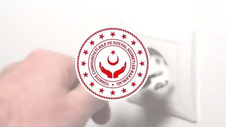 Bir el duvardaki elektrik anahtarına basarken üzerinde bakanlık logosu bulunan daire görülüyor.