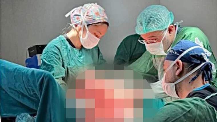 Ameliyathanede ameliyat kıyafetli dört sağlık çalışanı, üzeri piksellenmiş hastanın çevresinde duruyor.