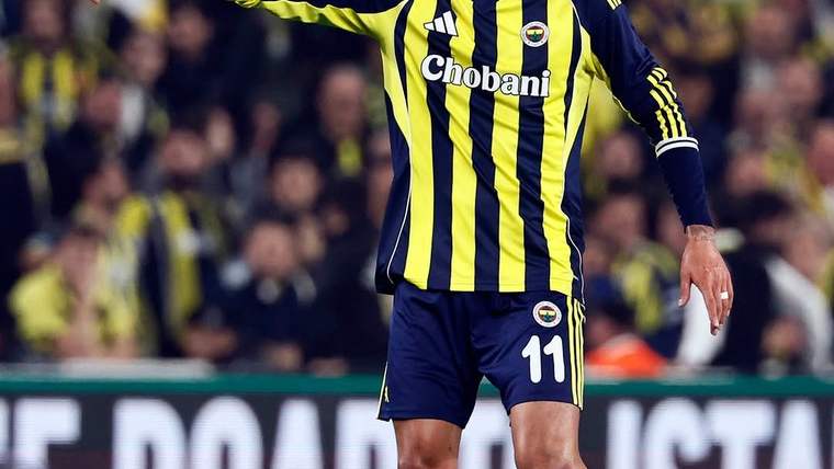 Sarı-lacivert çubuklu forma giyen 11 numaralı futbolcu, sahada kolunu uzatırken görülüyor.