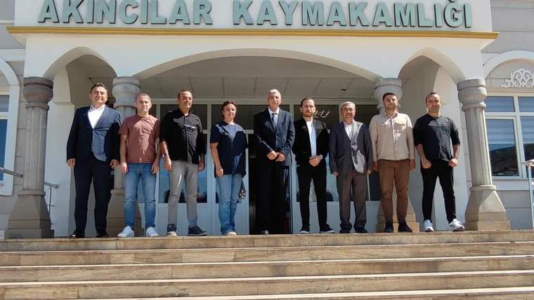 Akıncılar Kaymakamlığı önünde, sekiz kişi sırayla duruyor. Arkada kaymakamlık binası görünmekte.