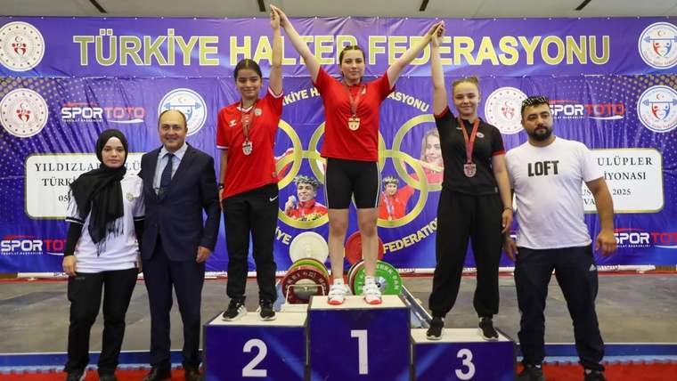 Halter podyumunda üç sporcu madalyalarıyla duruyor; çevrelerinde dört kişi, arkada Türkiye Halter Federasyonu pankartı var.
