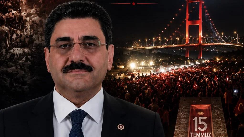 Bir kişi, arka planda kalabalık ve köprü ile birlikte 15 Temmuz yazılı bir pankartın önünde duruyor.