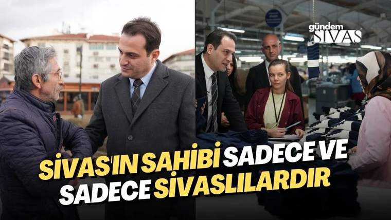 Bir kişi, başka bir kişiyle konuşuyor; arka planda bir grup insan ve binalar görünüyor.