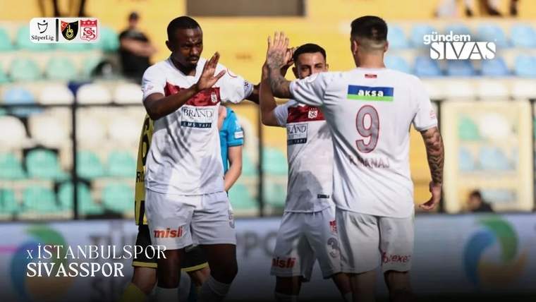 Beyaz formalı dört futbolcu sahada el çakarken, bir oyuncunun formasında 9 numarası görülüyor.