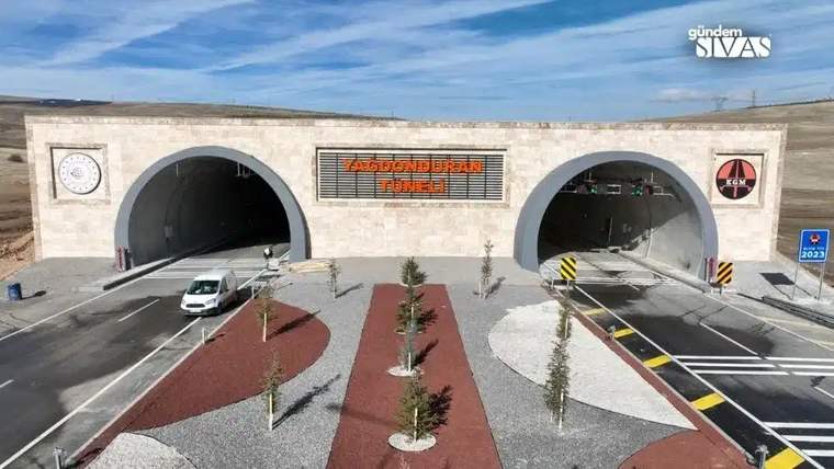 Yeni bir tünelin girişleri, yanlarında ağaçlar ve peyzaj düzenlemesi ile birlikte görünmekte.