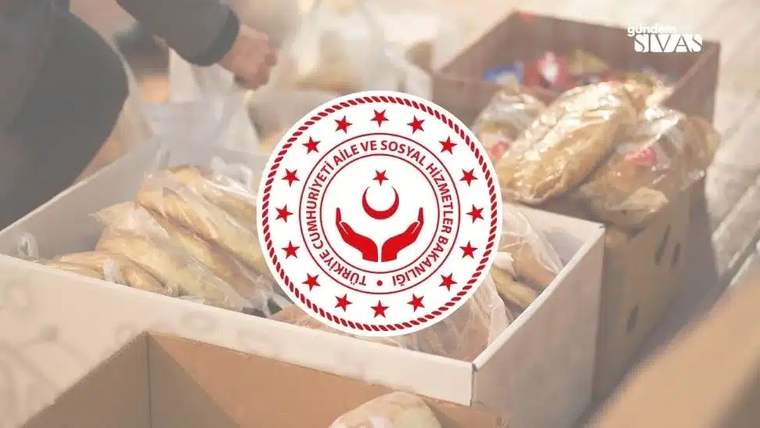 Yardım malzemelerinin bulunduğu kutuların önünde, Aile ve Sosyal Hizmetler Bakanlığı logosu yer alıyor.