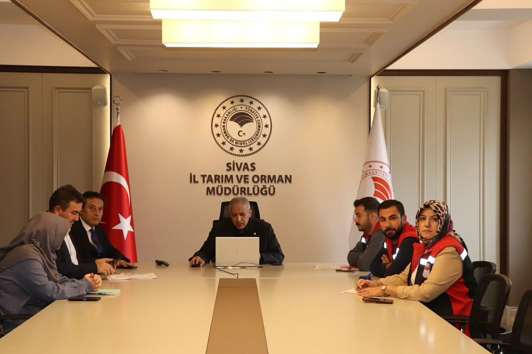 Bir toplantı odasında, masanın etrafında oturan altı kişi ve arka planda Türkiye bayrağı ile Sivas İl Tarım ve Orman Müdürlüğü tabelası.
