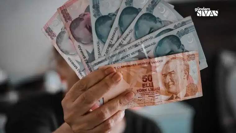 Bir kişi, elinde farklı banknotlardan oluşan bir deste para tutuyor.