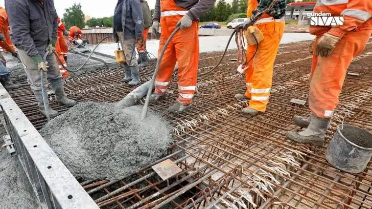 İnşaat alanında çalışan işçiler, beton dökme işlemi yapıyor.