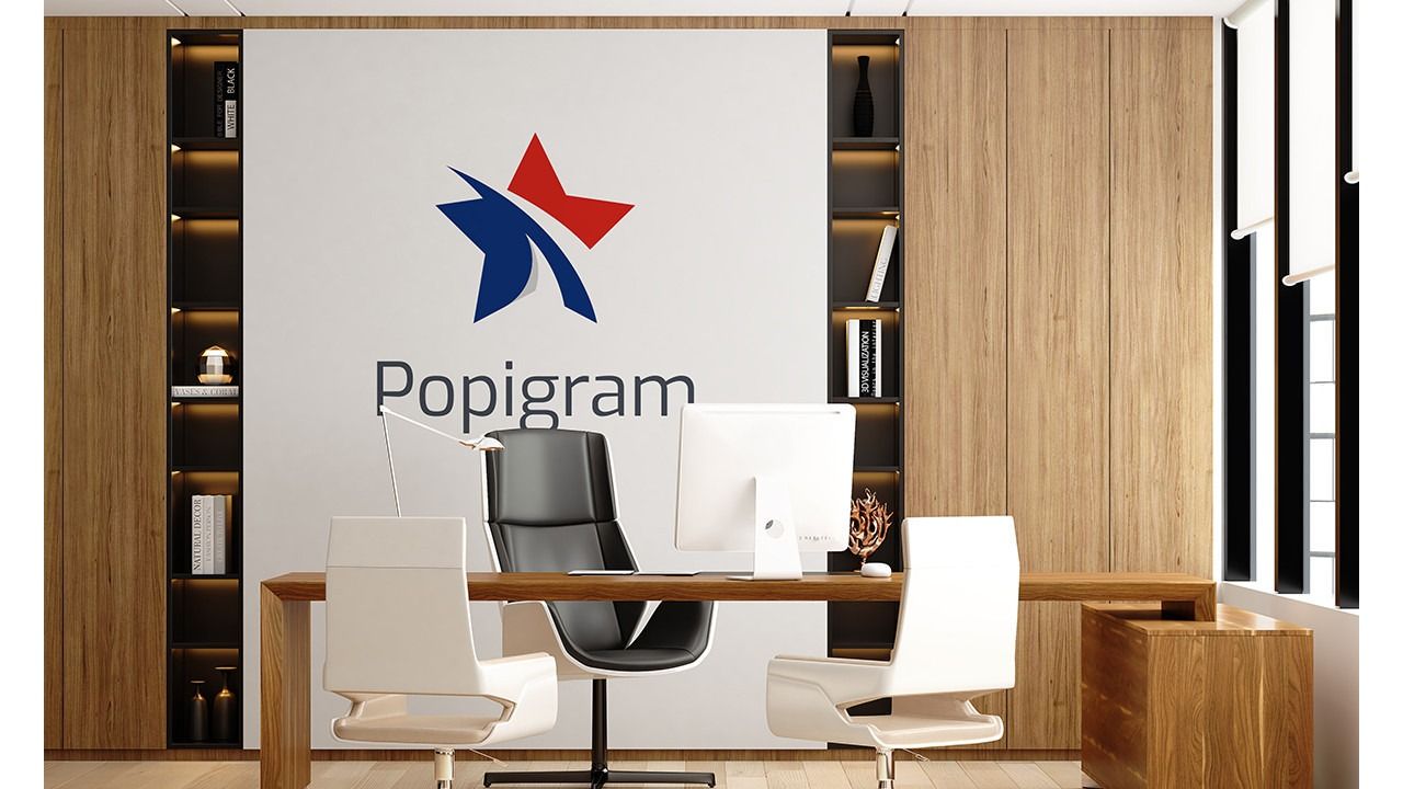 Popigram yazılı duvar önünde masa, bilgisayar ekranı, üç sandalye ve kitaplık bulunan modern ofis.