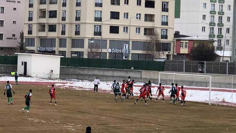 Futbol maçı sırasında kaleye doğru yapılan bir serbest vuruş anı, oyuncular kalabalık bir şekilde toplanmış.