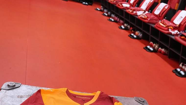 Galatasaray soyunma odasında, yerde bir forma ve sıralı koltuklar yer alıyor.
