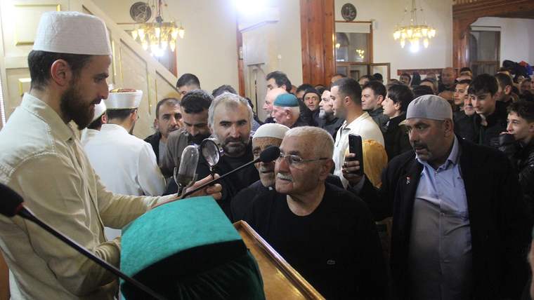Sakal-ı Şerif'in sergilendiği alanda kalabalık bir grup insan, bir kişiyi dinliyor.