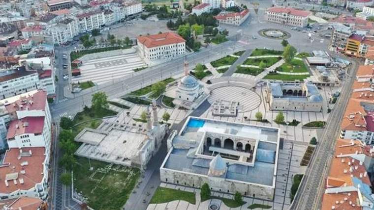 Sivas'ta bir meydan görünümü, çevresinde binalar ve yeşil alanlar var.
