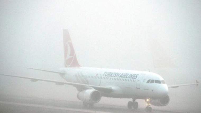 Sis nedeniyle görünürlüğü azalmış bir havaalanında, Türk Hava Yolları'na ait bir uçak duruyor.