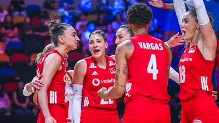 Kırmızı formalar giymiş beş kadın basketbolcu, sevinç içinde bir araya gelerek kutlama yapıyor.