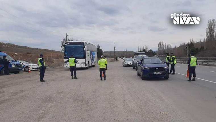 Reflektif yelekli görevliler, otobüs ve otomobillerin bulunduğu yolda trafik denetimi yapıyor.