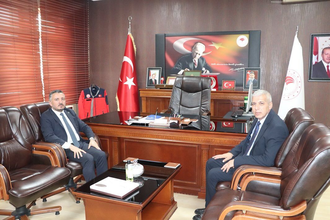 Sivas Tarım ve Orman İl Müdürlüğü'nde iki kişi, masa etrafında oturmuş, arka planda Türk bayrağı ve Atatürk posteri var.
