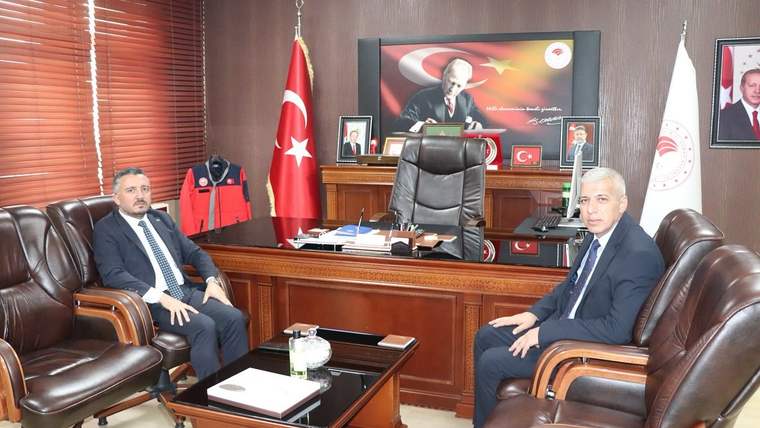 Sivas Tarım ve Orman İl Müdürlüğü'nde iki kişi, masa etrafında oturmuş, arka planda Türk bayrağı ve Atatürk posteri var.