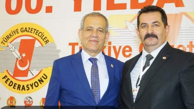 İki kişi, arka planda Türkiye Gazeteciler Federasyonu logosu ile birlikte poz veriyor.