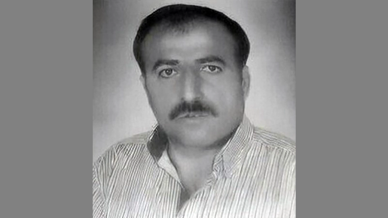 Bir erkeğin siyah beyaz portresi, gömlek giymiş ve ciddi bir ifadeye sahip.
