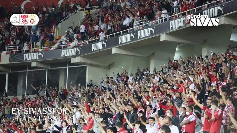 Sivasspor ve Galatasaray taraftarları, stadyumda coşkulu bir şekilde tezahürat yapıyor.