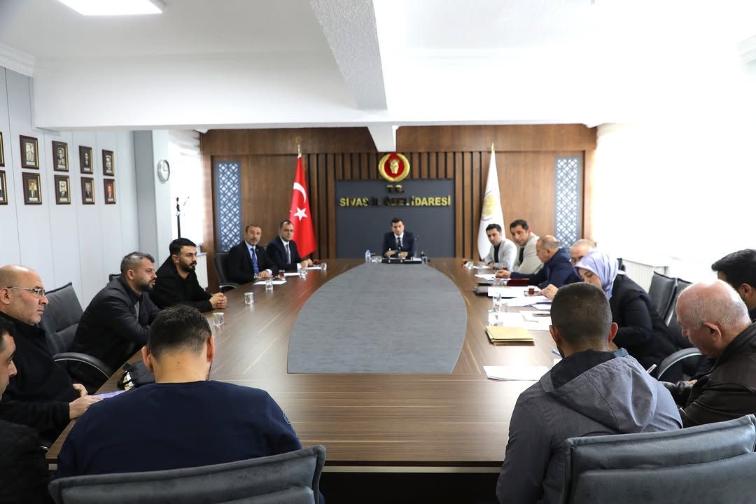 Sivas İl Özel İdaresi'nde bir toplantı odasında, masanın etrafında oturan katılımcılar yer alıyor.