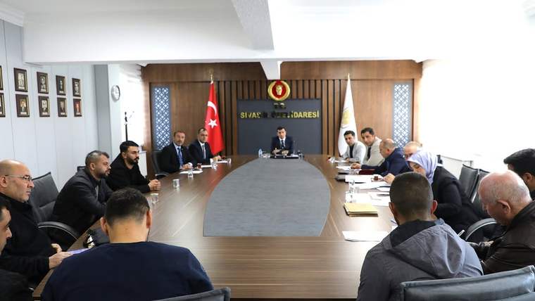 Sivas İl Özel İdaresi'nde bir toplantı odasında, masanın etrafında oturan katılımcılar yer alıyor.