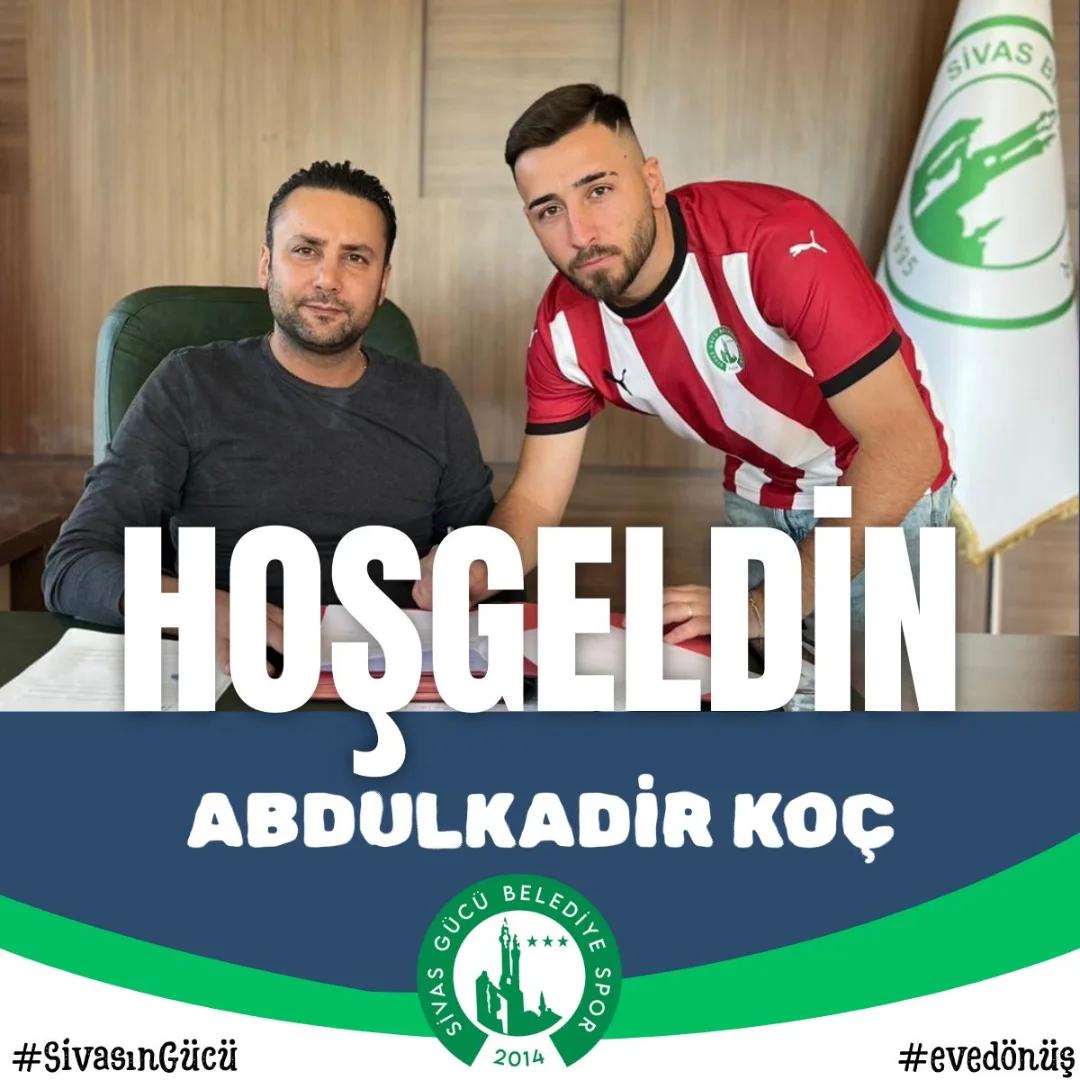 Masada oturan iki erkekten biri kırmızı beyaz çizgili forma giyiyor; afişte “Hoşgeldin Abdulkadir Koç” yazıyor.