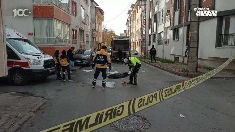 Sokakta, yerde yatan bir kişi ve etrafında sağlık ekipleri ile polisler var.