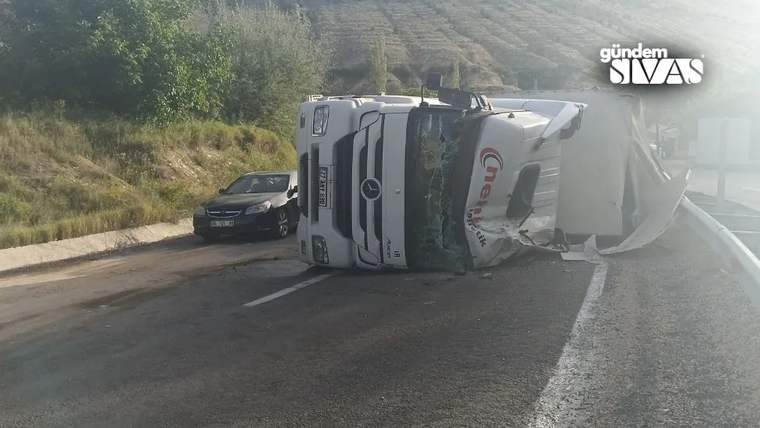 Yolda devrilmiş bir tır, yanında bir otomobil ile birlikte duruyor.