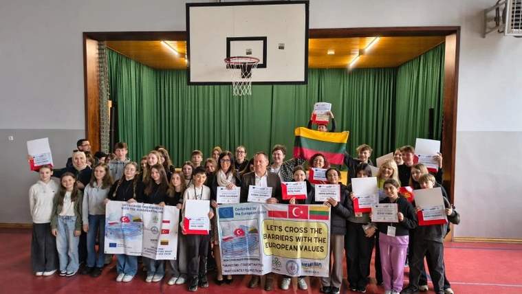 Spor salonunda basketbol potası önünde duran kalabalık grup, sertifika ve Türk bayraklı pankartlar taşıyor.