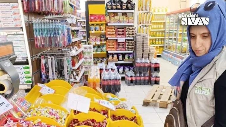 Bir kadın, markette şeker ve çikolata dolu tezgahın önünde duruyor.
