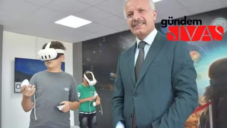 Sanal gerçeklik gözlüğü takan bir öğrenci ve yanında bir yetişkin, eğitim ortamında duruyor.