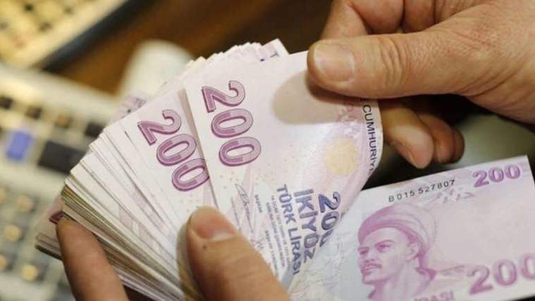 Eller, üzerinde Atatürk portresi bulunan Türk lirası banknotlarını deste hâlinde sayıyor.