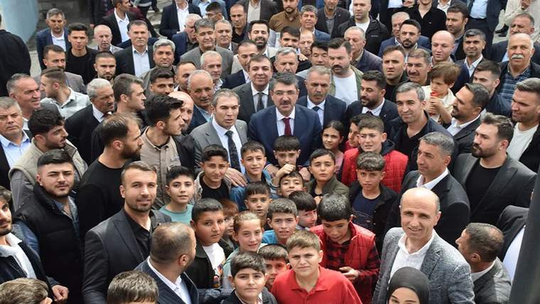 Bir grup insan, bir arada gülümseyerek poz veriyor; bazıları çocuk, bazıları yetişkin.