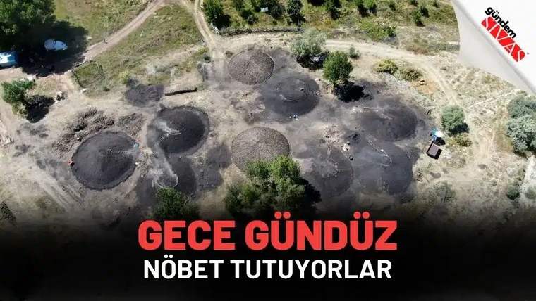 Kuru arazide çok sayıda yuvarlak koyu renkli alan, toprak yollar ve seyrek ağaçlar havadan görülüyor.