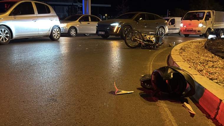 Yolda devrilmiş bir motosiklet ve kask, çevresinde duran araçlar var.