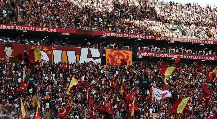 Stadyum tribünlerinde Türk bayrakları ve flamalar taşıyan taraftarlar, 29 Ekim kutlama pankartları arasında görülüyor.