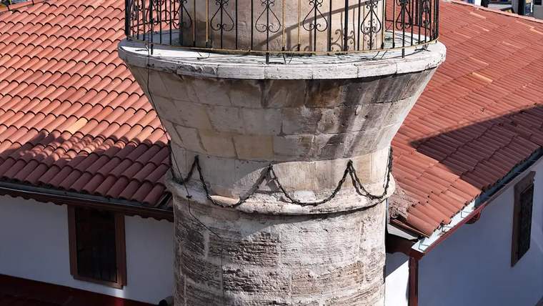Zincirli Minare Camisi'nin minaresinin üst kısmında demir zincirler ve taş yapısı görünmektedir.