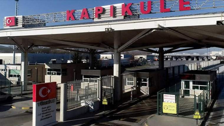Üzerinde “KAPIKULE” yazan gümrük geçiş alanında kontrol kulübeleri, bariyerler ve uyarı levhaları görülüyor.